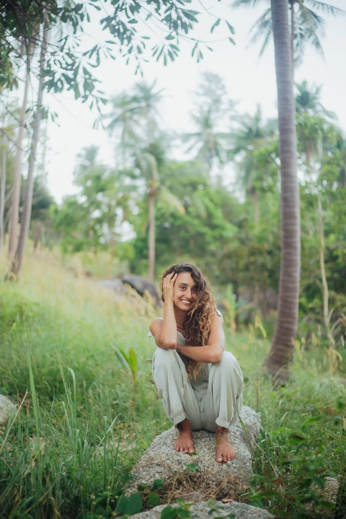 Soof smiling while seated barefoot in nature