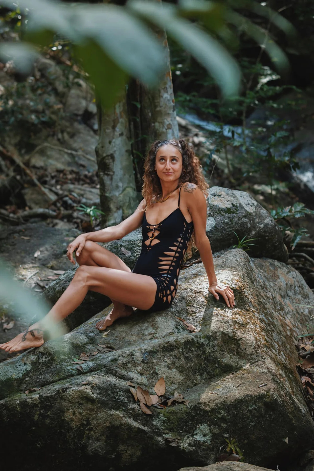 Soof seated among forest rocks in a moment of grounded reflection